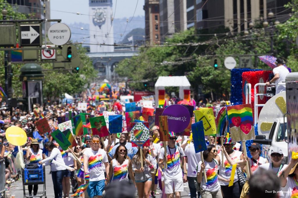 A diverse group of people walk during a pride parade.