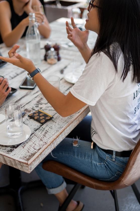 A group of friends talk about a table using verbal and nonverbal communication.