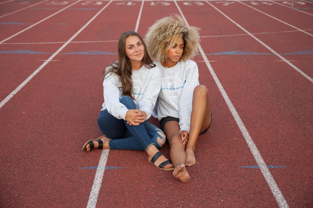 Two women sit on a track.