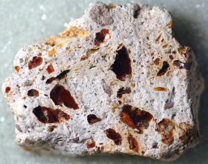 Pyroclastic texture shown by angular rock fragments mixed with fine ash and volcanic glass in igneous rock.