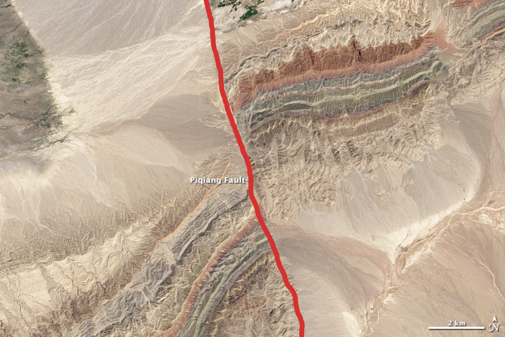 Same image of the Piqiang fault as above, but with a red line superimposed over the fault line.