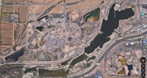 A satellite image showing mining operations near the main canal of the river in an urban setting