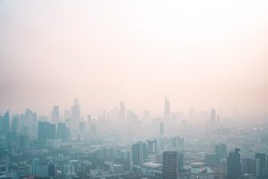 A picture of a city covered by a pinkish haze that covers the sky