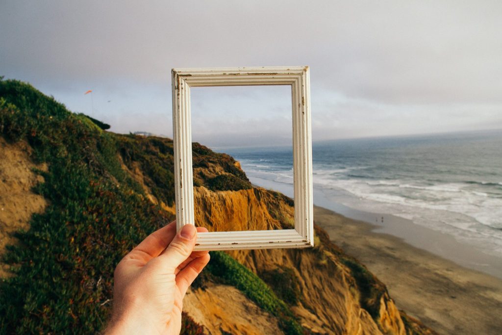 A mountainside and ocean framed within a picture