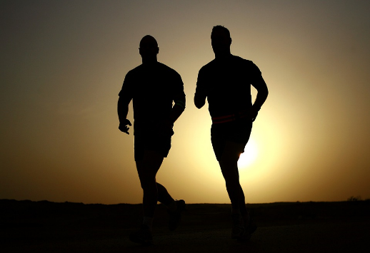 silhouette of two people running outside.