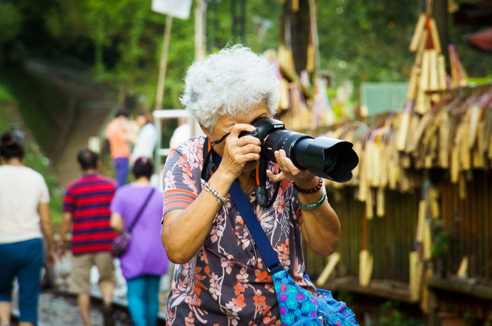 Older adult with a camera taking pictures