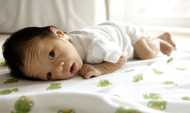 infant laying down on belly