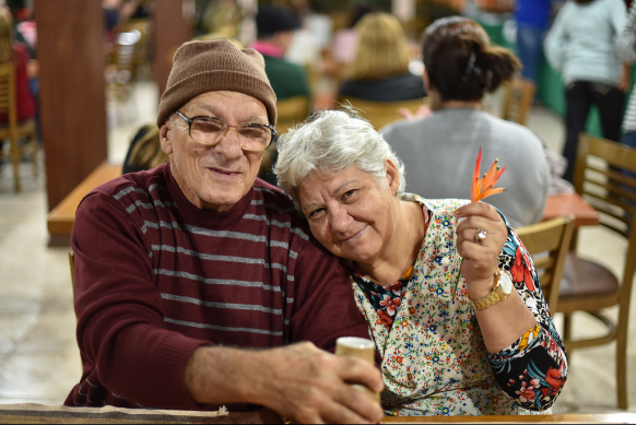 two elderly adults posting for a photo sitting down