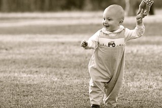 young child walking holding an adult hand