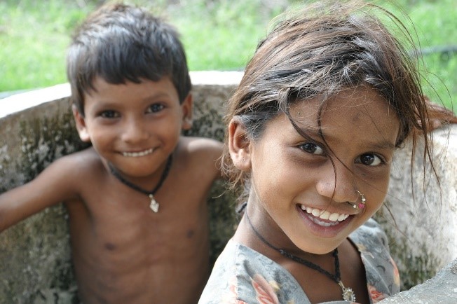 two children smiling outside