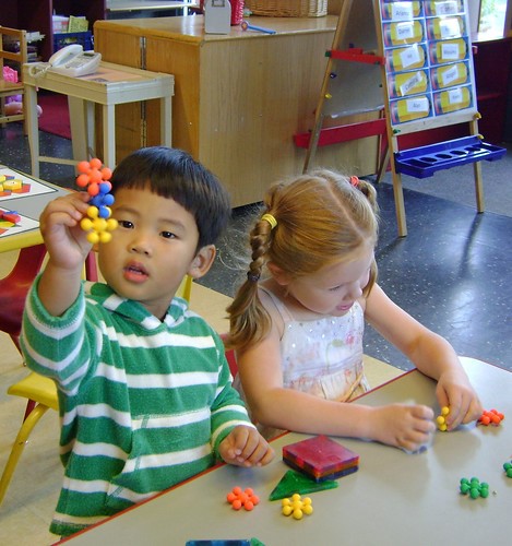 a young boy and girl playing with blocks