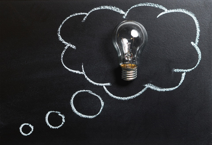 chalk board with thinking caption and lightbulb in the thinking cloud