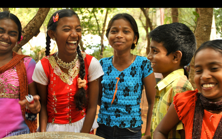 group of 5 kids standing together, laughing