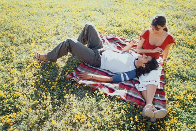 two people sitting on the grass on a blanket