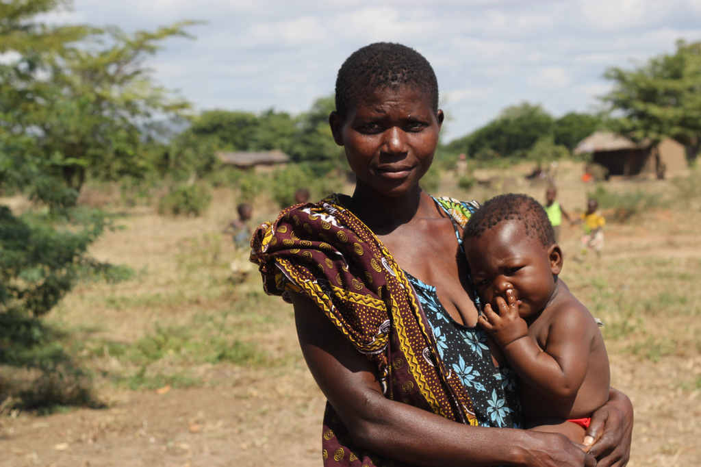 A young woman holding her infant child