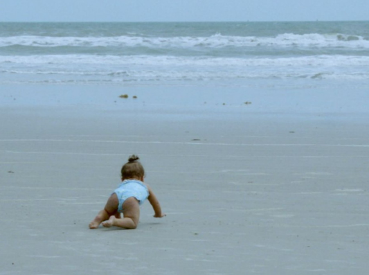 baby crawling on beach