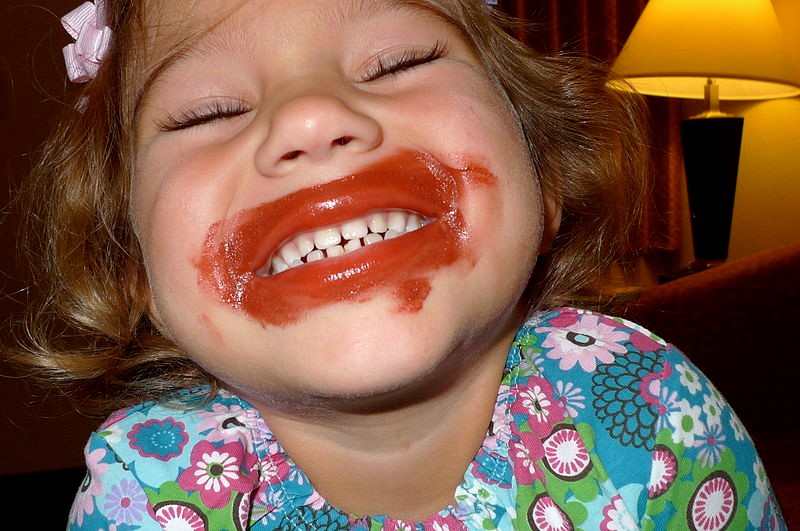 Young child with lipstick smeared all over mouth