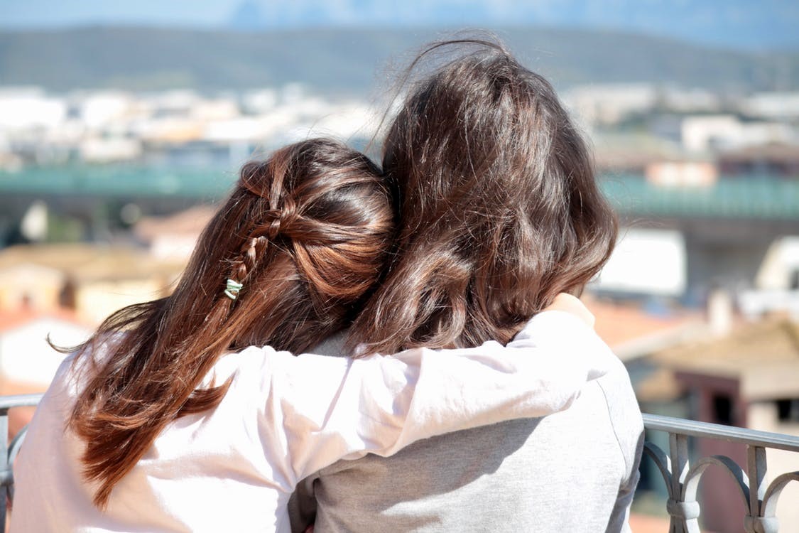 Back of mother and daughter hugging