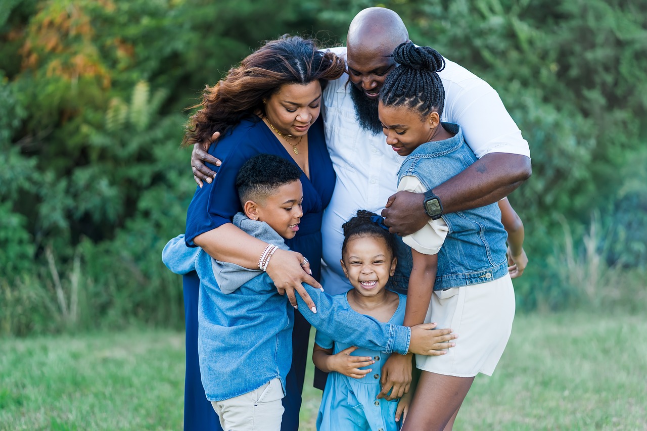 A family hugging with a mom, dad, and three children.