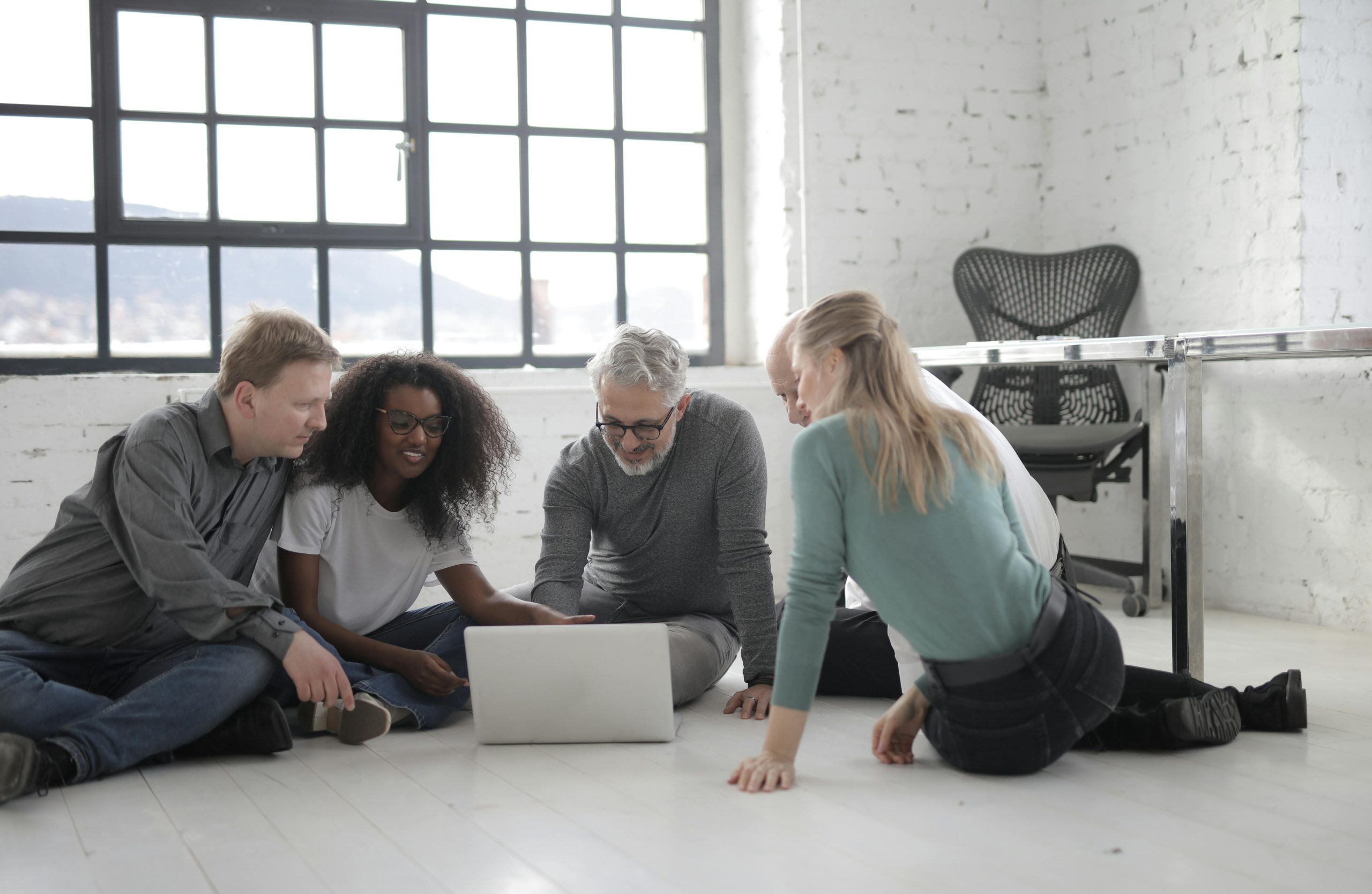 Group Of People Working While Seated On The Floor