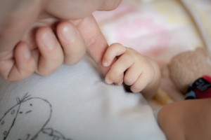 Baby grabs adult's hand