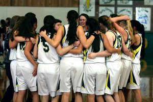 Women's basketball team in a group huddle