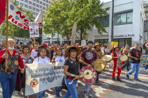 Protesters march and hold signs in opposition to the Dakota Access Pipeline