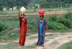 Photo of two women carrying water on their heads in India