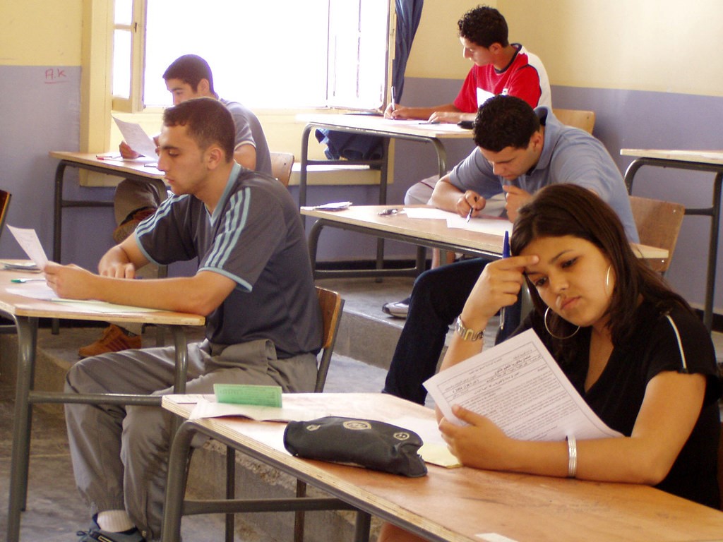 Algerian college students sitting in a classroom reading.