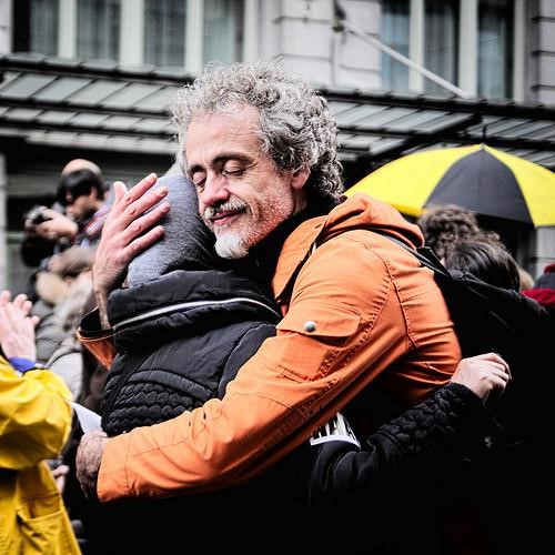A man hugging another man in large crowd.