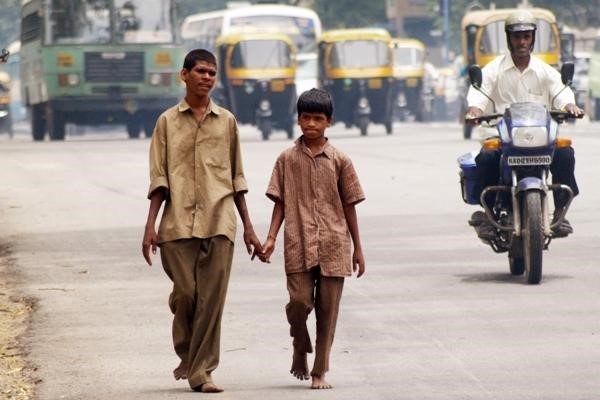 Two young men walking and holding hands.