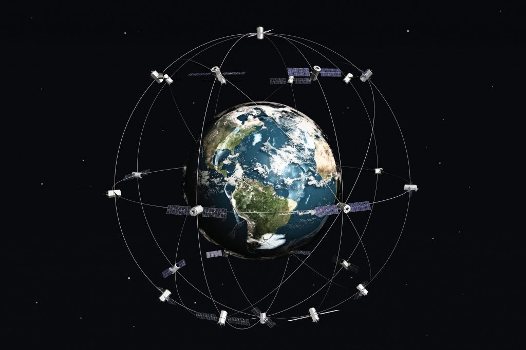 Satellites surround Earth all around, lines go between them representing signals sent and received.