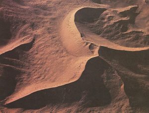 a dune iwth a central peak and many ridges formed by shifting winds