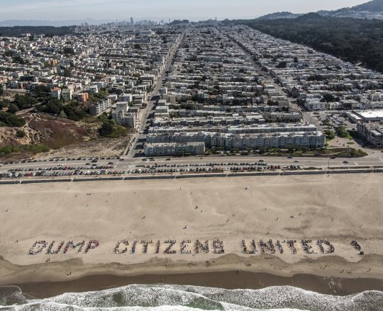 A beach with 'Dump Citizens United' written on it