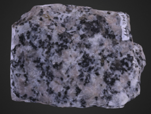 Light tan and pink coarse-grained rock with black flecks