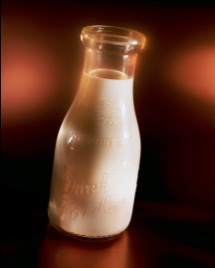 milk in a glass bottle on a brown background