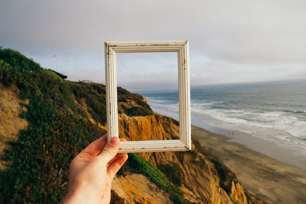 A mountainside and ocean framed within a picture