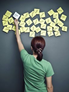 Woman carefully putting post it notes on wall