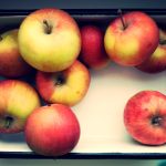 A white, rectangular container holding 9 apples