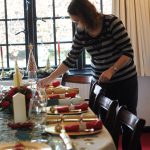 a woman setting a table for dinner