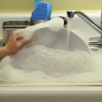 dishes being washed in a sink filled with soap