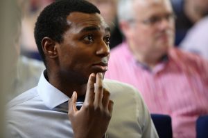 photo of a man in an audience listening to a speaker