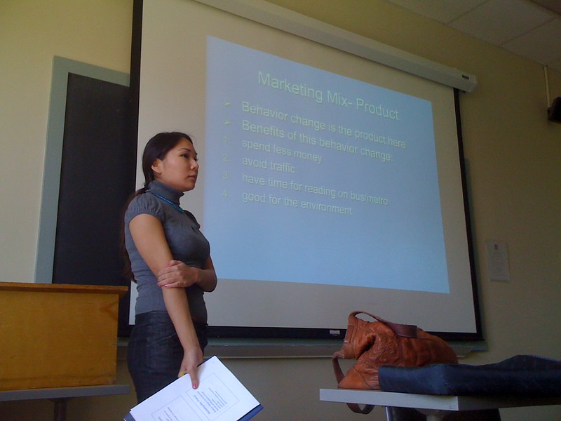 A woman doing a presentation with a paper on her hand as a presentation aid