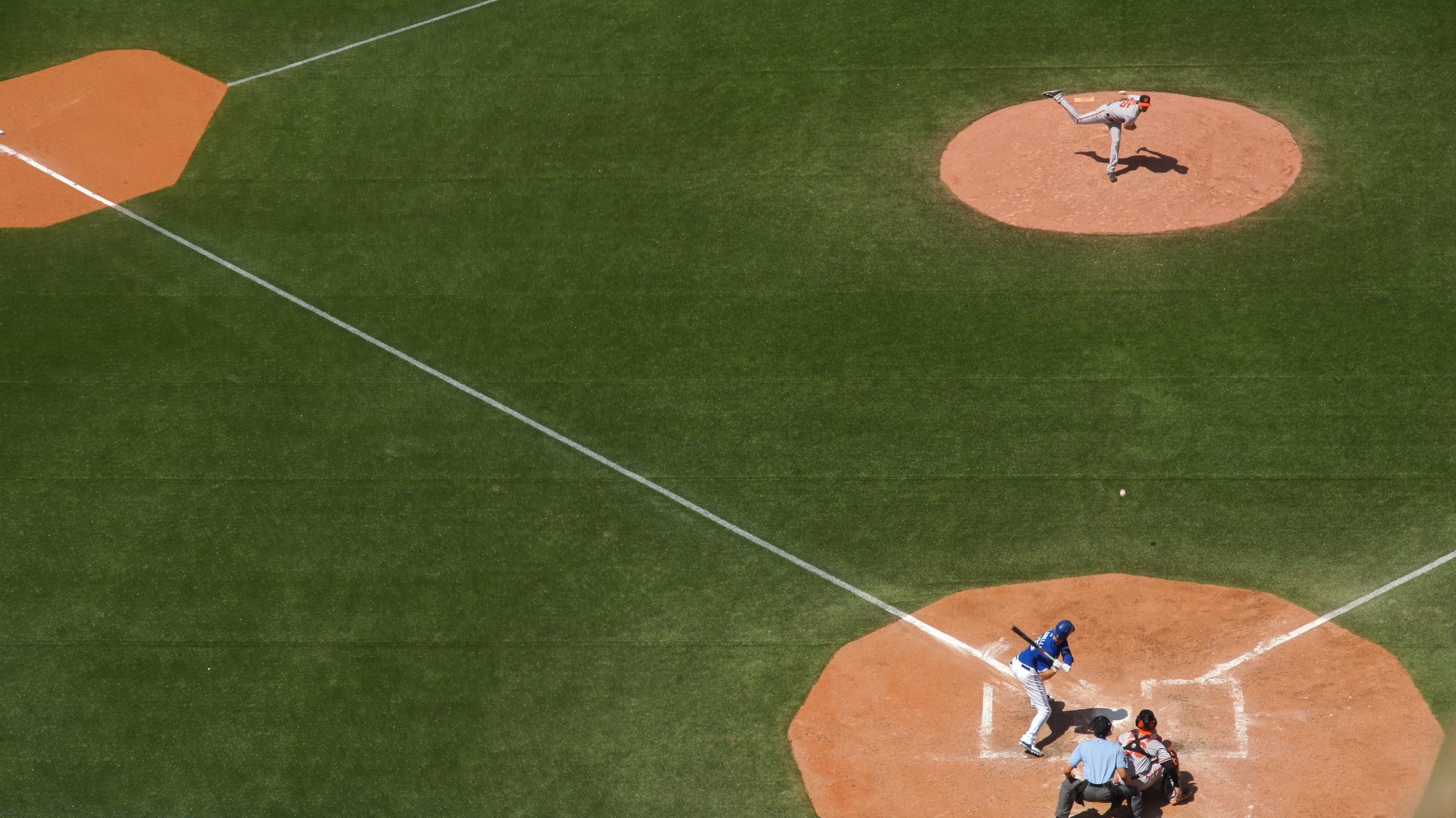 Three baseball players and a coach in the field during the baseball game in Toronto.