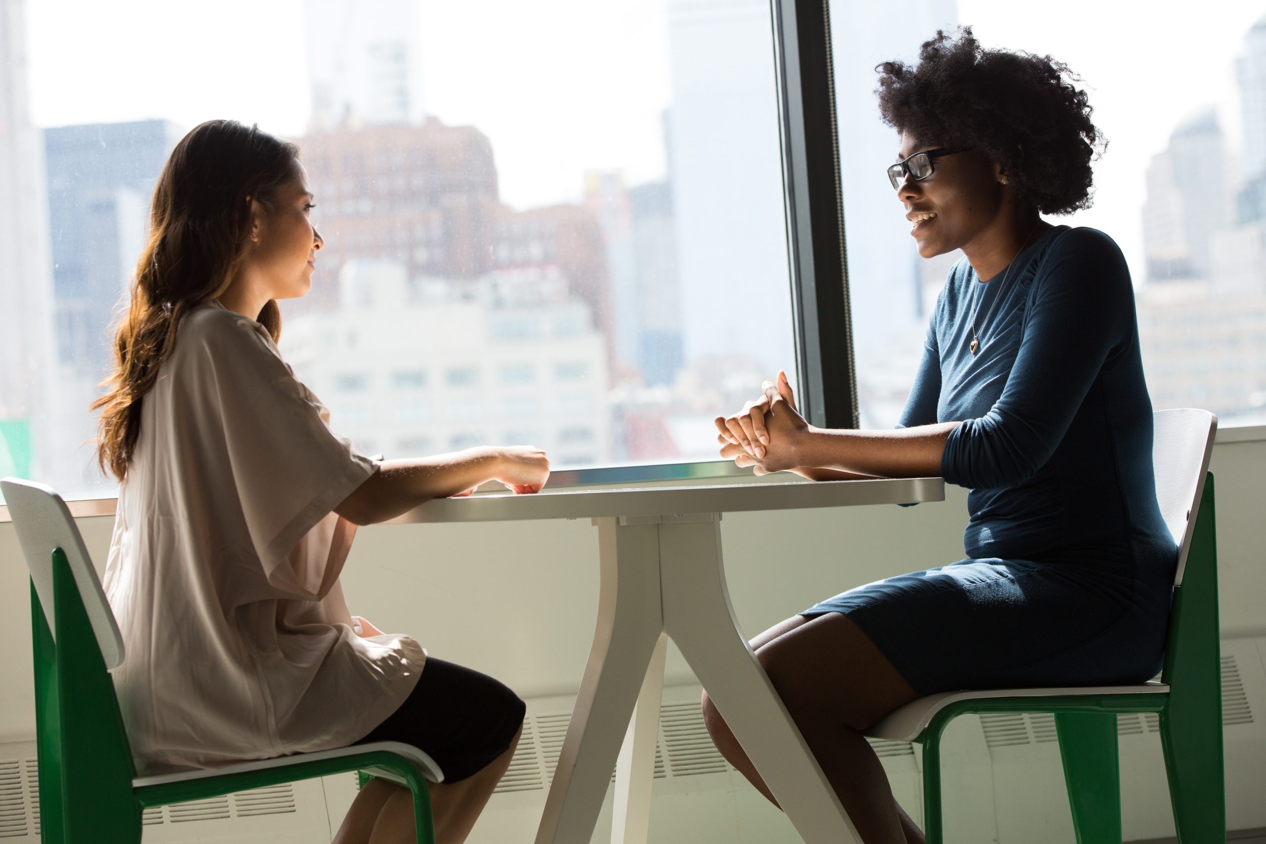 Two women talking across a table.