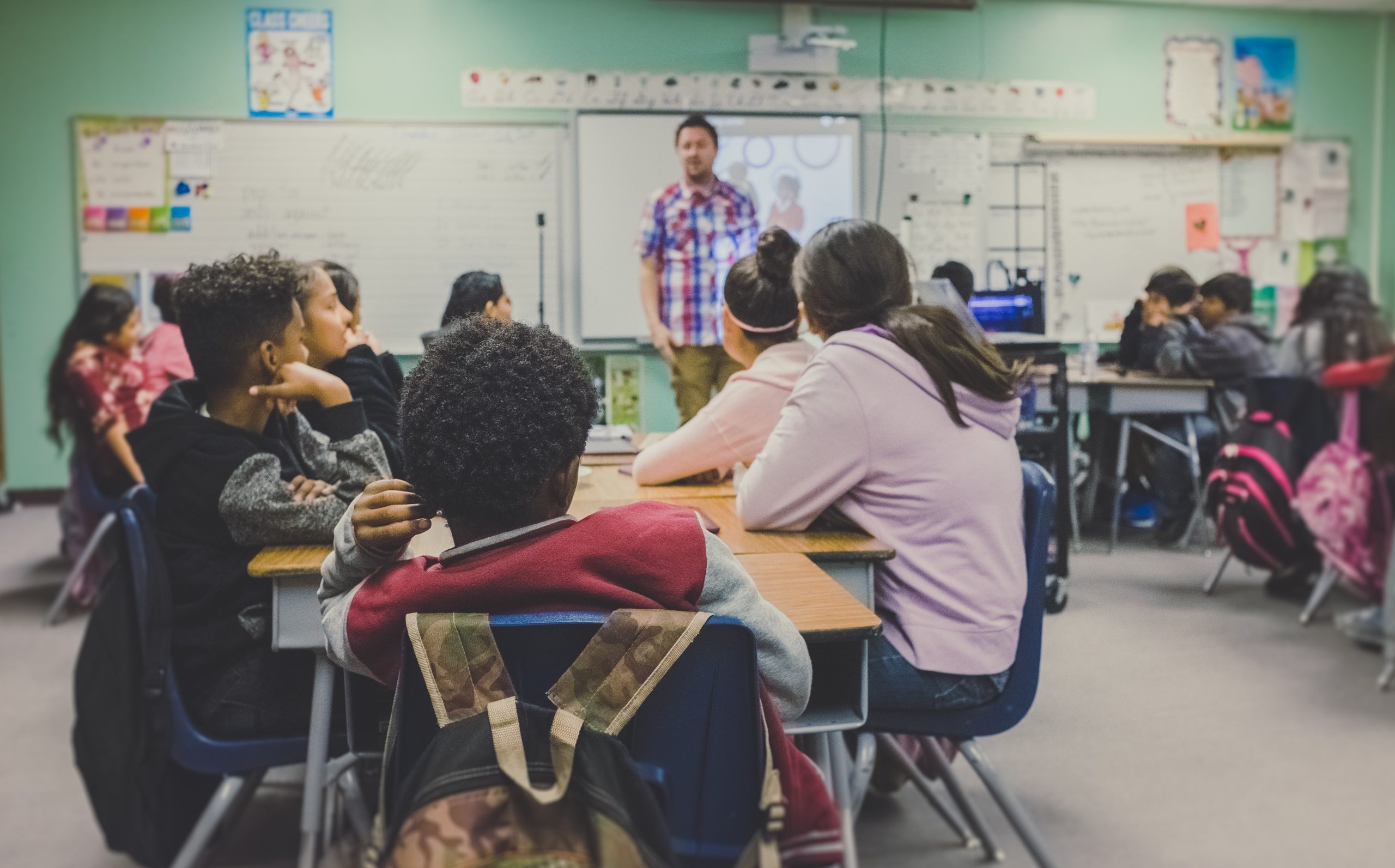 A teacher standing in front of the students in the classroom