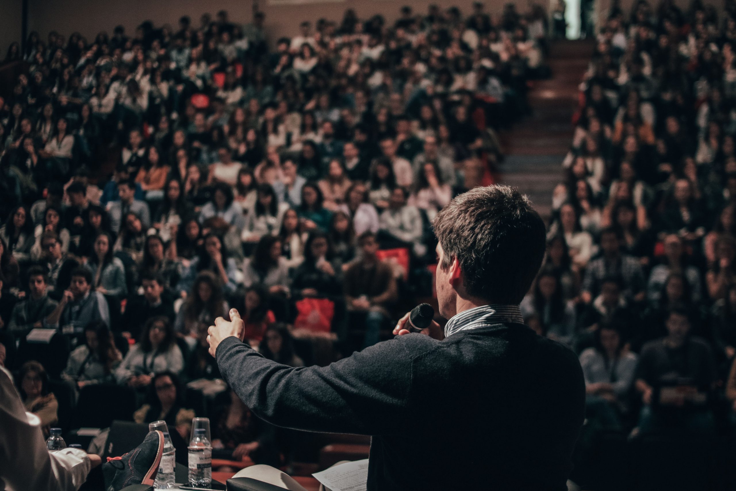 A man speaking in front of crowds.