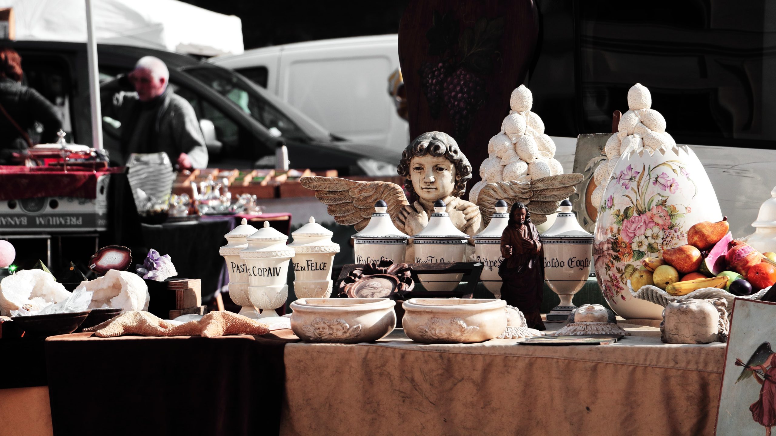 Various vases and statuettes at a table at a yard sale.