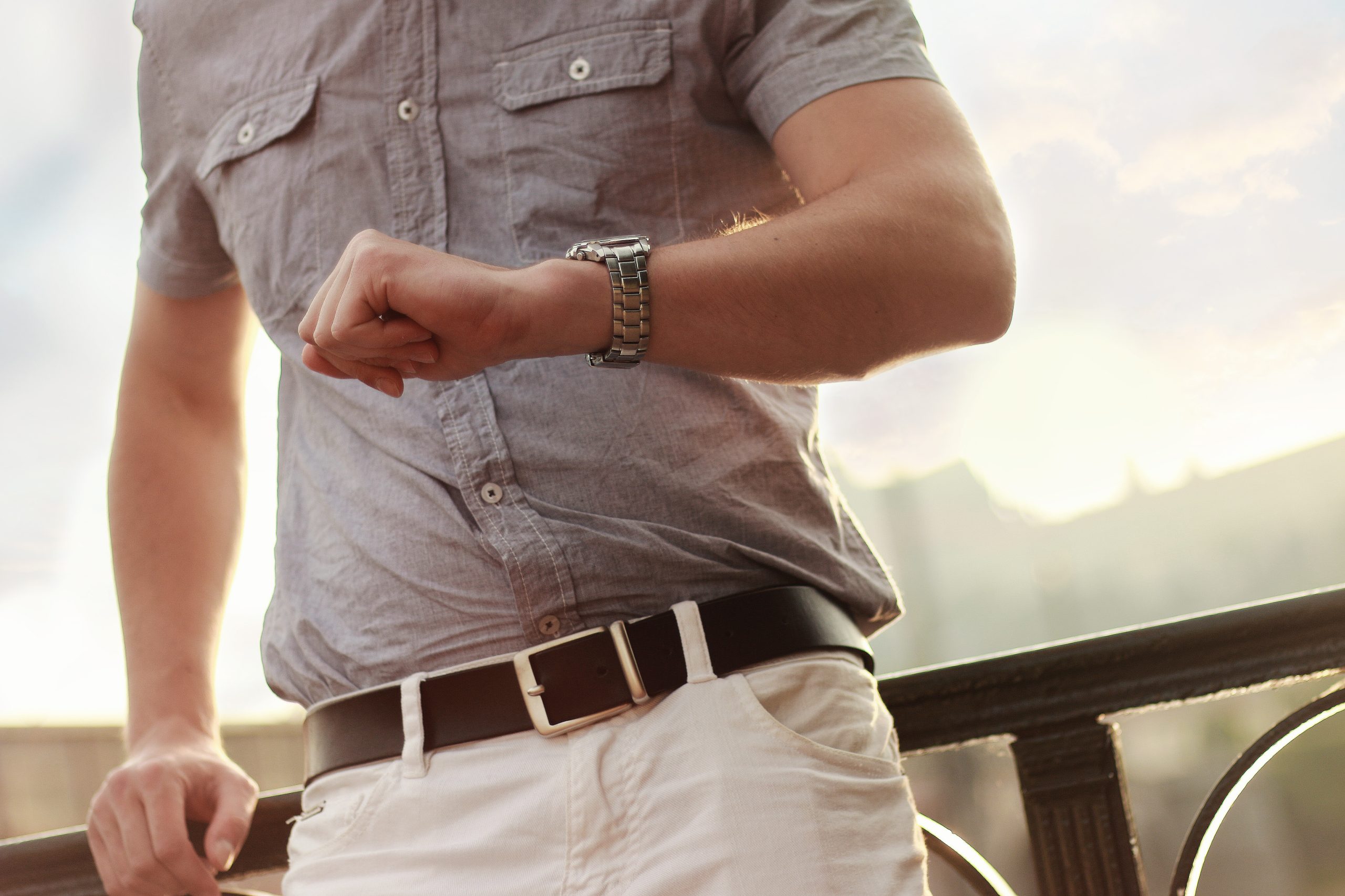 A man holds his arm wearing a watch up in front of him.