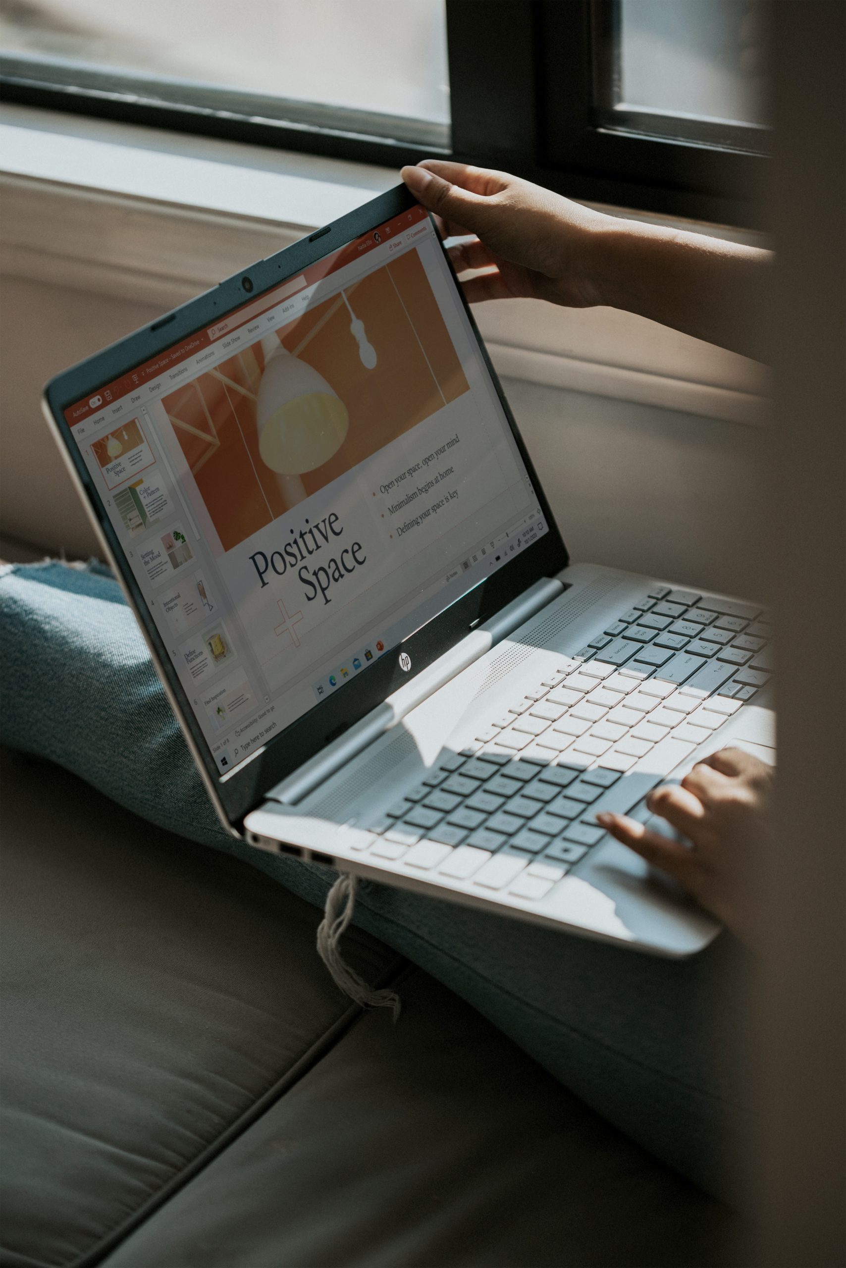 A laptop on the gray couch that displays a PowerPoint presentation, and two big words as the title says “Positive Space”.